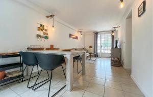 a kitchen with a white table and blue chairs at Amazing Home In Saint Pons La Calm in Saint-Pons-la-Calm