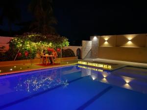 a pool at night with people sitting at a table at HOTEl LA CANDELARIA ROOM HOUSE in Mangue