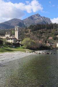 eine Kirche am Ufer eines Gewässers in der Unterkunft La Casa del Vicolo in Toscolano-Maderno