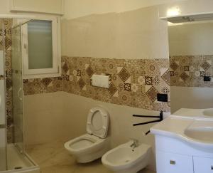 a bathroom with a toilet and a sink at Il Risveglio delle Onde 2 in Torre Ovo