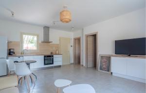 a kitchen with white cabinets and a flat screen tv at Splendide Villa Avec Piscine in Saint-Cézaire-sur-Siagne
