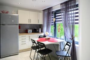 a kitchen with a table and chairs and a refrigerator at Located in the peaceful NG8 Wollaton , Perfect for Business Trips & Family Holidays or working proffesionals-long term deals, M1 Nearby , Free Parking , Private Garden , 500Mb Wi-Fi , Netflix in Nottingham