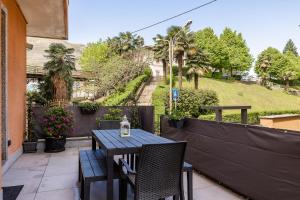 a table and chairs on a balcony with a view of a garden at Casa Blue Moon in Baveno