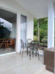 a patio with chairs and a table on a balcony at Grace Hill Villa Lubuk Minturun in Padang