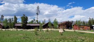 a group of buildings in a field next to a grass field at Reunion Lodge in Grand Lake