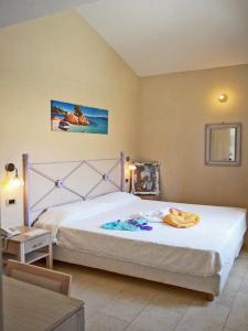 a bedroom with a large bed and a desk and a table at Hotel Mar & Sol in Punta Secca