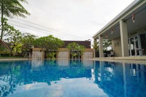 a swimming pool in front of a house at A&T House Sukabumi in Sukabumi