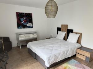 a bedroom with a bed and a night stand and a table at Appartement de standing T3 - Lina in Hésingue