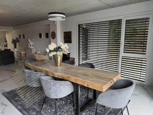 a dining room with a wooden table and chairs at Appartement de standing T3 - Lina in Hésingue