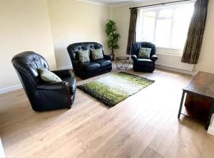 a living room with two chairs and a rug at The Annexe Hillside in Beetley +1 photo