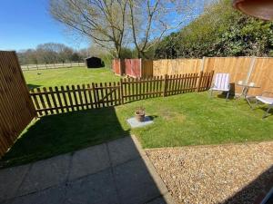 a backyard with a wooden fence and a bench at The Annexe Hillside in Beetley