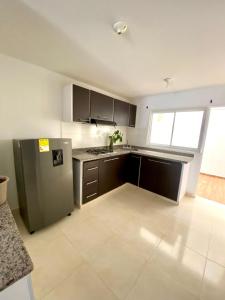a kitchen with a stainless steel refrigerator and cabinets at Casa en la capital turística de Santander in San Gil
