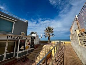 a building with stairs next to the beach at Hermoso piso en la playa in Miramar