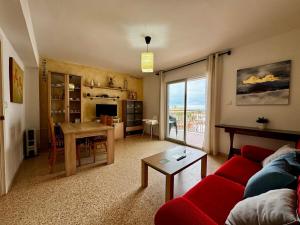 a living room with a red couch and a table at Hermoso piso en la playa in Miramar