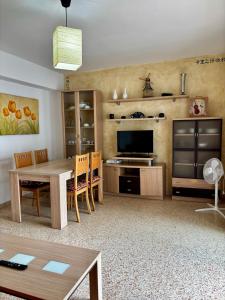 a living room with a table and a television at Hermoso piso en la playa in Miramar