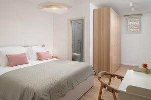 a white bedroom with a bed and a bathroom at Villa Casa Sorelle sea view infinity heated pool in Seline +58 photos