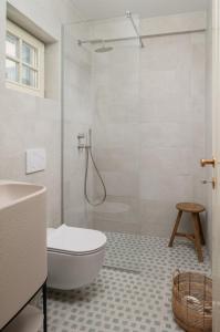 a bathroom with a shower and a toilet and a sink at Villa Casa Sorelle sea view infinity heated pool in Seline