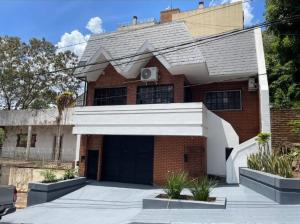 a brick house with a garage in front of it at Casa amplia en Costanera in Posadas