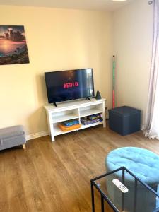 a living room with a flat screen tv on a white cabinet at Cosy two bedrooms flat suitable for a short trip in Portsmouth