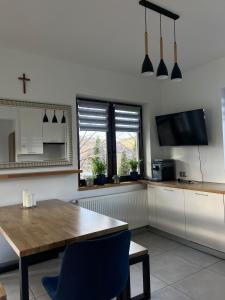a kitchen with a wooden table and a dining room at Domek Orłówka in Jaworzna