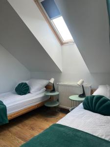 a attic bedroom with two beds and a window at Domek Orłówka in Jaworzna