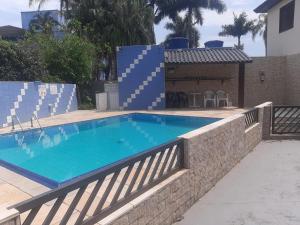 a swimming pool with a stone retaining wall at Condomínio Vila das Gaivotas - 05 in Bertioga