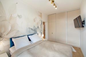a bedroom with a bed with a flowery wall at Aparts Care Beztroski Apartament Ku Morzu in Sianozety +20 photos
