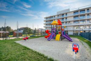 a playground in front of a building at Aparts Care Beztroski Apartament Ku Morzu in Sianozety