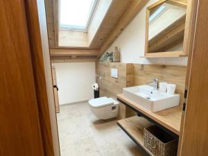 a bathroom with a white toilet and a sink at Ferienwohnung Kirmaier in Schwangau