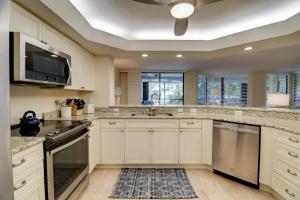 a kitchen with white cabinets and a ceiling at Pine Cove 204 in Sanibel