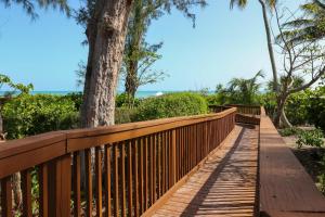 a wooden walkway with a tree on it at Pine Cove 204 in Sanibel