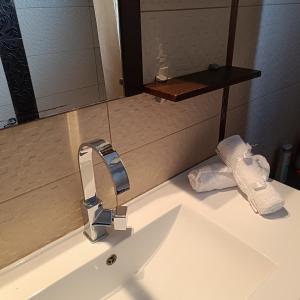 a bathroom sink with a faucet and towels on it at Koni Guesthouse in Kos Town +15 photos
