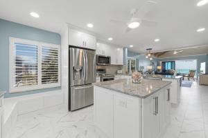 a kitchen with white cabinets and stainless steel appliances at Pine Cove 403C in Sanibel
