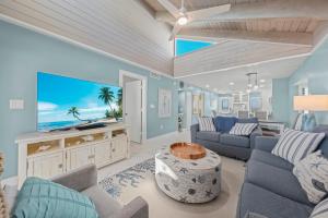 a living room with blue walls and a large screen tv at Pine Cove 403C in Sanibel