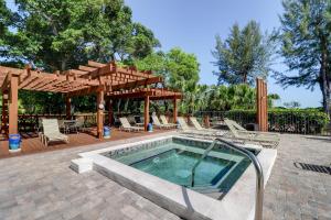 a swimming pool with chairs and a wooden pergola at Pine Cove 403C in Sanibel