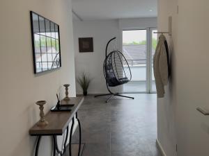 a living room with a desk and a chair in it at Luxus-Penthouse mit Terrasse & Klima in Siegburg
