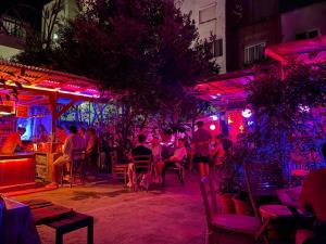 a group of people sitting at a restaurant at night at Tirana Backpacker Hostel in Tirana