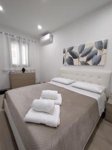 ein Schlafzimmer mit einem großen Bett mit Handtüchern darauf in der Unterkunft Manenti Holiday House in Noto
