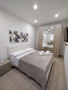 Un dormitorio con una cama grande y un espejo. en Manenti Holiday House, en Noto