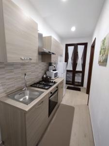 una cocina con fregadero y estufa en Manenti Holiday House, en Noto