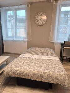 a bedroom with a bed and a clock on the wall at Escapade dans le Verdon classé 3 étoiles in Riez