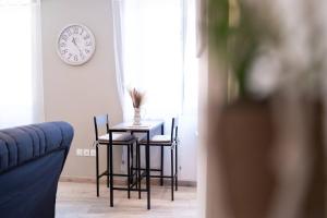 a table and chairs in a room with a clock on the wall at Escapade dans le Verdon classé 3 étoiles in Riez