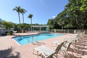 a swimming pool with lounge chairs and a swimming pool at Gone Coastal in Sanibel