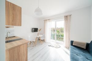 a kitchen and living room with a table and a window at Apartament 01, Rodzinny z Tarasem, Grzybowo Centrum - Nadmorska 26 in Grzybowo +50 photos