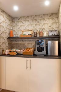 a kitchen with white cabinets and a counter with a microwave at Hôtel Avama Prony in Paris