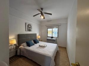 a bedroom with a bed with a ceiling fan at Hermoso piso en la playa in Miramar