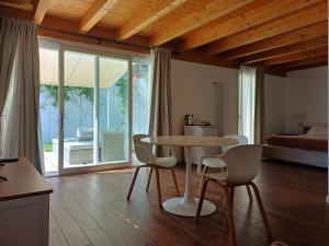 a room with a table and chairs and a bedroom at Carmen de Nella Eco Lodge 4* in Caprino Veronese