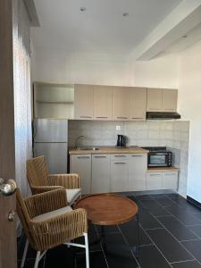 a kitchen with a table and two chairs and a microwave at Tropical Suites in Flogita