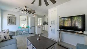 a living room with a couch and a flat screen tv at Little Palm Cottage in Sanibel