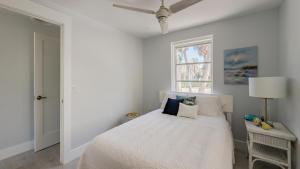 a white bedroom with a bed and a window at Little Palm Cottage in Sanibel +18 photos